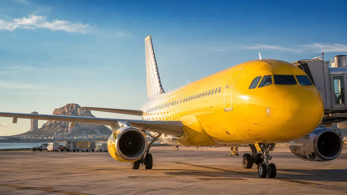Aereo Vueling giallo a terra davanti all'aerostazione, che illustra il rimborso delle tasse Vueling